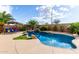Backyard pool with unique stone waterfall features, lush tropical landscaping, and sunny lounge area at 12526 S 176Th Ave, Goodyear, AZ 85338