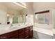 Bright bathroom features a double sink vanity, soaking tub, large mirror and a separate shower at 1289 E Baker Dr, San Tan Valley, AZ 85140