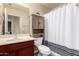 Bathroom with sink, toilet, linen cabinet, and shower with a decorative striped curtain at 1289 E Baker Dr, San Tan Valley, AZ 85140