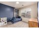Bright bedroom featuring blue accent wall, climbing gym, window with neighborhood views and play kitchen at 1289 E Baker Dr, San Tan Valley, AZ 85140