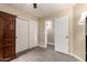 Bedroom with wood look floors, large armoire, and closet with double doors at 1289 E Baker Dr, San Tan Valley, AZ 85140