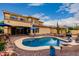 Backyard view of a two-story home featuring a pool, a lounge area, desert landscaping, and a clear blue sky at 13336 W Via Caballo Blanco --, Peoria, AZ 85383