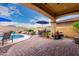 Inviting backyard patio with a pristine pool, desert landscaping, and a cozy outdoor dining area under a shaded structure at 13336 W Via Caballo Blanco --, Peoria, AZ 85383