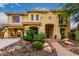 Elegant, two-story home with a stucco exterior, arched entryway, desert landscaping, and a porte-cochère at 13336 W Via Caballo Blanco --, Peoria, AZ 85383