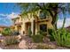 Stunning two-story home featuring an arched entry, decorative tile roof, private balcony, and desert landscaping at 13336 W Via Caballo Blanco --, Peoria, AZ 85383