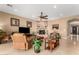 Cozy living room featuring a stone fireplace, a ceiling fan, and comfortable seating at 13336 W Via Caballo Blanco --, Peoria, AZ 85383