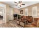 Comfortable living room features wood floors, fan, and cozy brown couches at 13336 W Via Caballo Blanco --, Peoria, AZ 85383