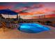 Inviting pool featuring desert landscaping, lounge chairs, and a vivid sunset at 13336 W Via Caballo Blanco --, Peoria, AZ 85383