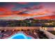 Inviting pool featuring desert landscaping, illuminated hardscape and a stunning view of mountains under a colorful sunset at 13336 W Via Caballo Blanco --, Peoria, AZ 85383