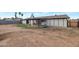 View of the backyard with a covered patio, palm trees, brick wall, and white-painted rear exterior at 1410 W Morrow Dr, Phoenix, AZ 85027