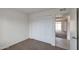 This bedroom features a closet with folding doors, neutral carpet, and a view through the doorway to an adjacent room at 1410 W Morrow Dr, Phoenix, AZ 85027