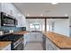 Updated kitchen with stainless appliances, butcher block countertops, and a tile backsplash, seamlessly blending style at 1410 W Morrow Dr, Phoenix, AZ 85027