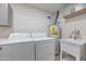 Laundry room with washing machine, dryer, utility sink, water heater, and storage cabinets above at 1410 W Morrow Dr, Phoenix, AZ 85027