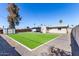 Landscaped backyard featuring artificial turf, gravel, and a covered patio, perfect for outdoor entertaining at 14842 N 36Th St, Phoenix, AZ 85032