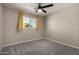 Bedroom showcasing carpeted floors, a window with bright yellow curtains, and ample neutral tones at 14842 N 36Th St, Phoenix, AZ 85032