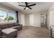 Bright living room with wood-look tile floors, ceiling fan, and comfortable gray sofa at 14842 N 36Th St, Phoenix, AZ 85032