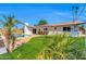 Exterior showcasing pool, well-maintained lawn, and a covered patio, all set against a clear blue sky at 1643 W Harmont Dr, Phoenix, AZ 85021