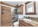 Bathroom with tiled shower, granite vanity, and dark wood cabinet at 1643 W Harmont Dr, Phoenix, AZ 85021