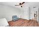 A bedroom featuring wood floors, a ceiling fan, and a soft blue seating area at 1643 W Harmont Dr, Phoenix, AZ 85021