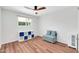 Bedroom showcasing wood floors, a window with natural light, and a cozy blue seating area at 1643 W Harmont Dr, Phoenix, AZ 85021