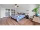 Bright bedroom with hardwood floors, fan and glass sliding closet doors at 1643 W Harmont Dr, Phoenix, AZ 85021