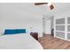 Bedroom with white bedding, wood floors, and a sliding door closet, offering storage at 1643 W Harmont Dr, Phoenix, AZ 85021