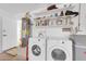A utilitarian laundry area with modern appliances, water heater and shelving for ample storage at 1643 W Harmont Dr, Phoenix, AZ 85021