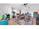 Bright living room featuring a ceiling fan, wood-look floors and colorful rug at 1643 W Harmont Dr, Phoenix, AZ 85021