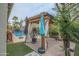 Lush backyard featuring a pergola, patio seating, a refreshing pool, and mature landscaping elements at 17985 W Jojoba Rd, Goodyear, AZ 85338