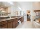 Luxurious bathroom featuring double sinks, granite countertops, and a soaking tub at 17985 W Jojoba Rd, Goodyear, AZ 85338