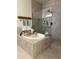Luxurious bathroom showcases a relaxing soaking tub with tiled surround and separate glass enclosed shower at 17985 W Jojoba Rd, Goodyear, AZ 85338