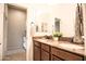 Bathroom featuring double sink vanity with granite countertop, wooden cabinetry and modern fixtures and decorative plant at 17985 W Jojoba Rd, Goodyear, AZ 85338