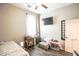 Cozy bedroom with a ceiling fan, side table, and a comfortable sitting area with a comfy chair at 17985 W Jojoba Rd, Goodyear, AZ 85338