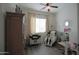 Bright bedroom with ceiling fan, wood-look floors, and modern massage chair at 17985 W Jojoba Rd, Goodyear, AZ 85338