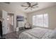 Comfortable bedroom with a large window, ceiling fan, and a cozy armchair with a faux fur throw at 17985 W Jojoba Rd, Goodyear, AZ 85338