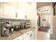 Butler pantry with granite countertops, white cabinetry, and convenient beverage station at 17985 W Jojoba Rd, Goodyear, AZ 85338