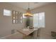 Charming dining area featuring modern lighting fixture, stylish table setting and two windows at 17985 W Jojoba Rd, Goodyear, AZ 85338