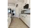 Bright kitchen with white cabinets, stainless steel appliances, and tan backsplash tiles at 17985 W Jojoba Rd, Goodyear, AZ 85338