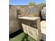 Outdoor kitchen with a stone bar, a decorative tile backsplash, and travertine walls at 17985 W Jojoba Rd, Goodyear, AZ 85338