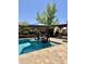 Swimming pool with in-pool seating and a cabana covered in white drapery at 17985 W Jojoba Rd, Goodyear, AZ 85338