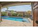 Stunning backyard oasis with a sparkling pool, inviting seating area, and lush landscaping for ultimate relaxation at 17985 W Jojoba Rd, Goodyear, AZ 85338