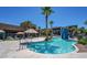 Resort-style pool area with palm trees, umbrellas, and modern outdoor furniture at 17985 W Jojoba Rd, Goodyear, AZ 85338
