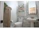 Stylish powder room with patterned tile backsplash, pedestal sink and cabinet at 17985 W Jojoba Rd, Goodyear, AZ 85338