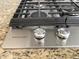 Close-up of a KitchenAid stovetop with stainless steel knobs, highlighting its sleek design and functionality at 17985 W Jojoba Rd, Goodyear, AZ 85338