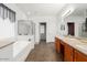 Spacious bathroom boasts double sinks, soaking tub, shower and tile flooring at 18325 W Port Au Prince Ln, Surprise, AZ 85388