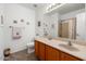 Well-lit bathroom featuring tile floor, toilet, vanity sink, mirror and shower with curtain at 18325 W Port Au Prince Ln, Surprise, AZ 85388