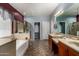 Bathroom featuring tile flooring, double sinks, a soaking tub, and a glass enclosed shower at 18325 W Port Au Prince Ln, Surprise, AZ 85388