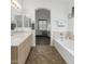 Modern bathroom featuring tile flooring, double sinks, a soaking tub, and light neutral colors at 18325 W Port Au Prince Ln, Surprise, AZ 85388