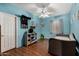 Bright blue bedroom featuring laminate floors, a ceiling fan, and a neutral sofa at 18325 W Port Au Prince Ln, Surprise, AZ 85388