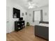Bright bedroom featuring laminate floors, a ceiling fan, and a neutral sofa at 18325 W Port Au Prince Ln, Surprise, AZ 85388